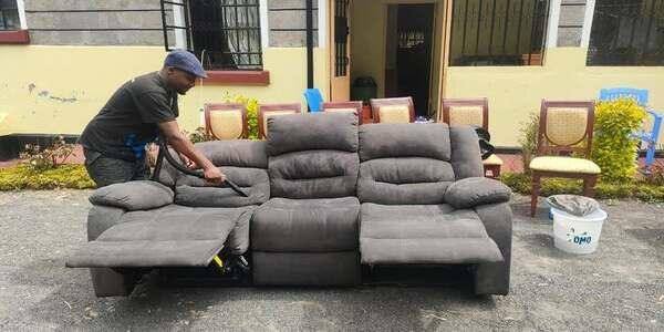 A cleaner working on a fabric sofa